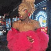 a woman in a pink dress stands in front of a sign that says " midnight "
