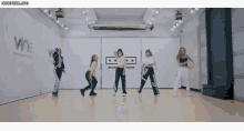a group of women are dancing in a room with a sign that says wne entertainment