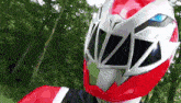 a close up of a person wearing a red and white superhero helmet .