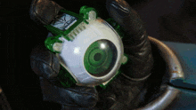 a person is holding a green and white toy that says ghost buster on it