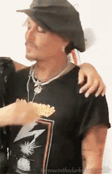 a man wearing a black shirt with a lightning bolt on it is being hugged by another man