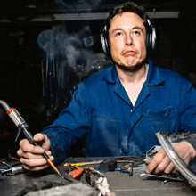 a man wearing headphones is working with a soldering iron