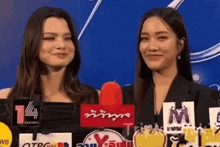 two women are standing next to each other in front of a microphone with a sign that says ' t4 ' on it