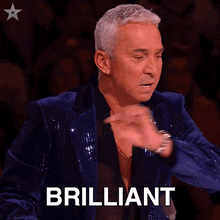 a man in a blue sequined jacket says brilliant in front of a crowd
