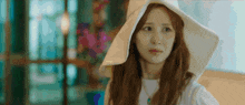 a woman wearing a white hat is making a funny face .