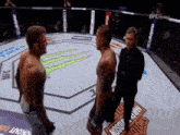 two men are standing in a ring with a harley davidson logo on the floor