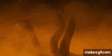 a group of people are standing in front of a fire in a cave .