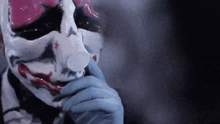 a close up of a person wearing a clown mask and gloves .