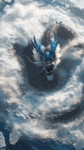 a blue and white dragon is flying through the clouds .