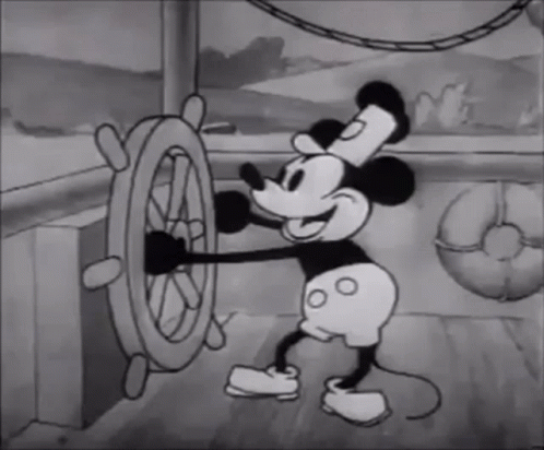 A classic black and white animation of a cartoon mouse cheerfully steering a ship's wheel