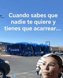 a row of blue aguacaliente buses are parked in a parking lot next to a woman