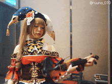 a woman in a jester costume is holding a violin with the hashtag @ruuna_070 on the bottom right