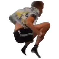 a man is squatting down with his legs crossed and his shirt off .