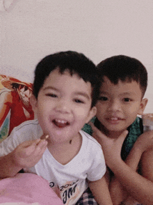 two young boys are posing for a picture and one of them is wearing a shirt that says " we are "