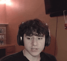 a young man is wearing headphones and making a funny face
