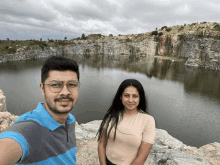 a man and a woman are standing in front of a large body of water