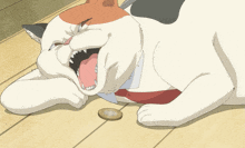 a cat is laying on the floor with its mouth open and a coin in its paw