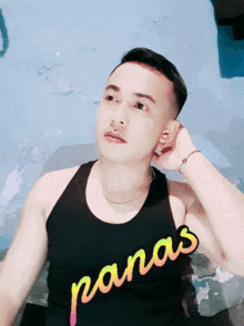 a man is wearing a tank top that says panas on it
