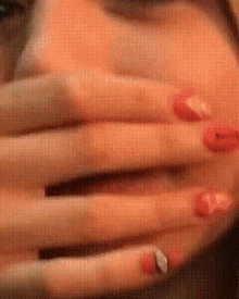 a close up of a person covering their mouth with their hands .