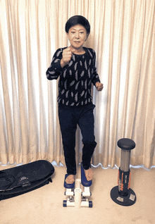 a woman in a black sweater stands on a stepper