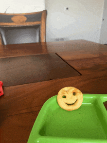 a green tray with a smiling potato chip on it