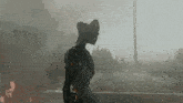 a statue of a man in a cowboy hat is walking in the fog