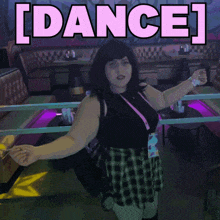 a woman in a black top and plaid skirt stands in front of a dance sign