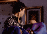 a man in a plaid shirt is holding a woman in a blue cloth