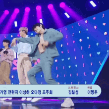 a man in a blue suit is dancing on a stage with purple lights