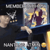 a man is standing in front of a shelf with a picture of a man and the words member latihan nantang atmin