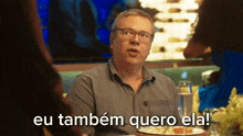 a man sitting at a table with a plate of food and the words eu também quero ela written below him