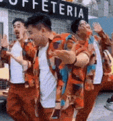 a group of young men are dancing in front of a buffetteria .
