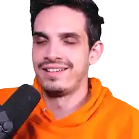 a man wearing an orange sweatshirt is smiling while talking into a microphone