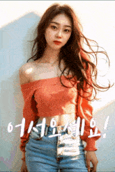 a woman in an orange off the shoulder top is standing in front of a white wall