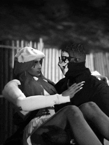 a black and white photo of a man and a woman with the man wearing a skeleton mask