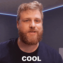 a man with a beard wearing a black shirt with the word cool on it