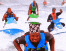 a man wearing a bandana and a life jacket is riding a jet ski