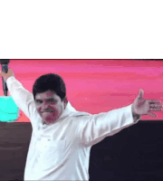a man in a white shirt is standing with his arms outstretched and holding a microphone .
