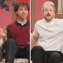 two men are sitting on a couch and one is wearing a white shirt