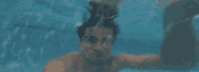 a man is swimming under water in a swimming pool .