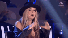 a woman wearing a black hat and a black jacket is on a television screen that says #the dancer estreno