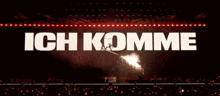 a crowd of people watching a fireworks display with the words ich komme in white letters