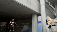 a robot is standing in front of a building with a sign that says 46 on it