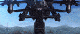 a large robot is flying through the air in front of mountains .