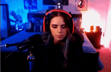 a woman wearing headphones sits in front of a microphone that says shure