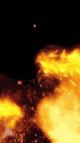 a close up of a fire with sparks flying in the air