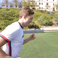 a man running on a field wearing a nike shirt