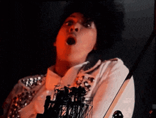 a man with a surprised look on his face playing a guitar
