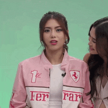 a woman wearing a pink jacket that says ferrari