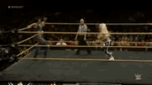 a wrestler is laying on the floor in a wrestling ring while a referee watches